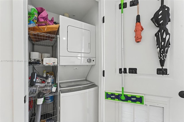 washroom featuring stacked washer / drying machine and laundry area