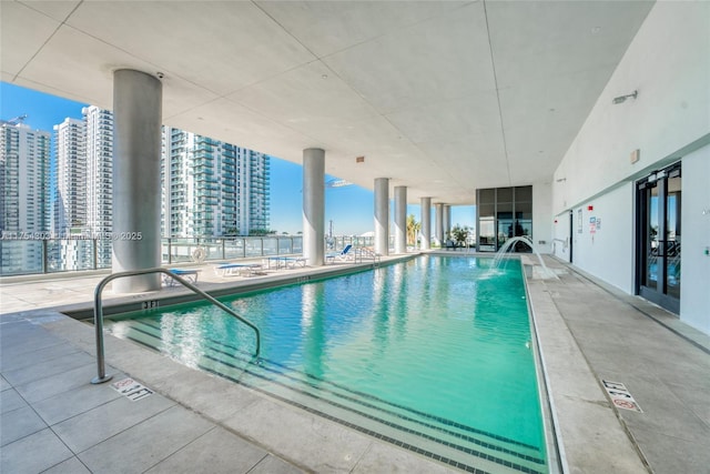 pool with a patio area and a city view