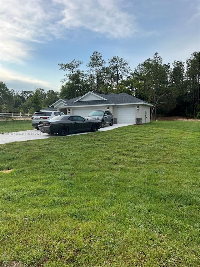 view of side of property featuring a yard, an attached garage, fence, and stucco siding