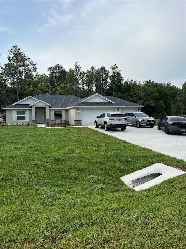 ranch-style house featuring concrete driveway, a front lawn, and an attached garage