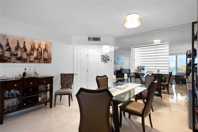 dining space with visible vents and a textured ceiling