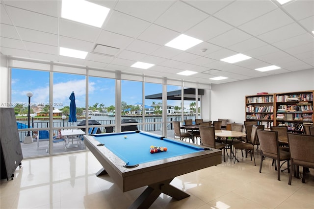 recreation room with a drop ceiling, a wall of windows, and a wealth of natural light