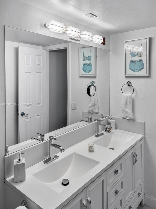 521 N Riverside Dr Unit 808, Pompano Beach, FL 33062 - full bath with visible vents, a sink, a textured ceiling, and double vanity