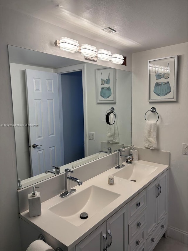 521 N Riverside Dr Unit 808, Pompano Beach, FL 33062 - bathroom featuring visible vents, a sink, a textured ceiling, and double vanity