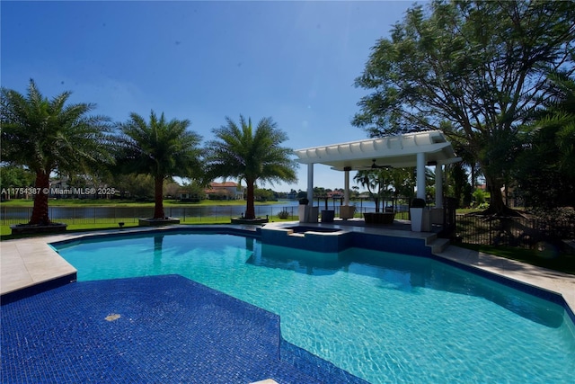 view of swimming pool featuring ceiling fan, a pool with connected hot tub, fence, and a patio