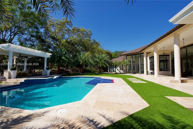 pool with a yard, a patio area, and a ceiling fan