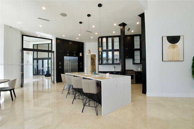2980 Windmill Ranch Rd, Weston, FL 33331 - kitchen with dark cabinets, a large island, a kitchen bar, light countertops, and light marble finish floors