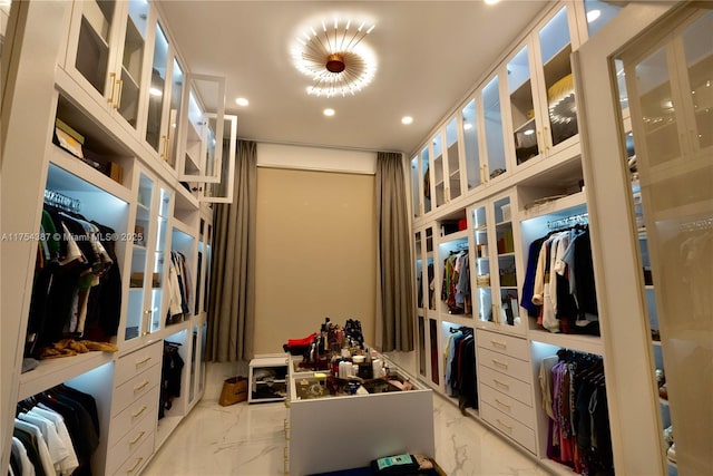 walk in closet featuring marble finish floor