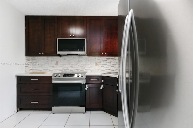 kitchen featuring light tile patterned floors, stainless steel appliances, tasteful backsplash, and light countertops