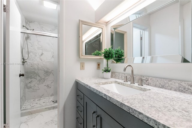 full bathroom featuring marble finish floor, a marble finish shower, and vanity