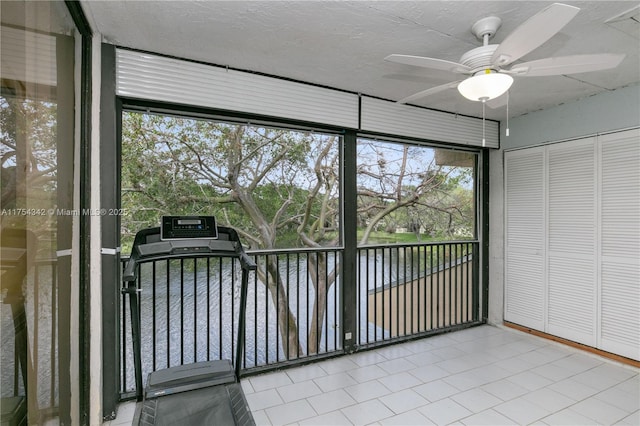 unfurnished sunroom with a ceiling fan