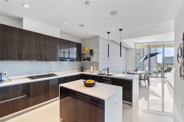 kitchen featuring a kitchen island, modern cabinets, a sink, and stainless steel gas stovetop