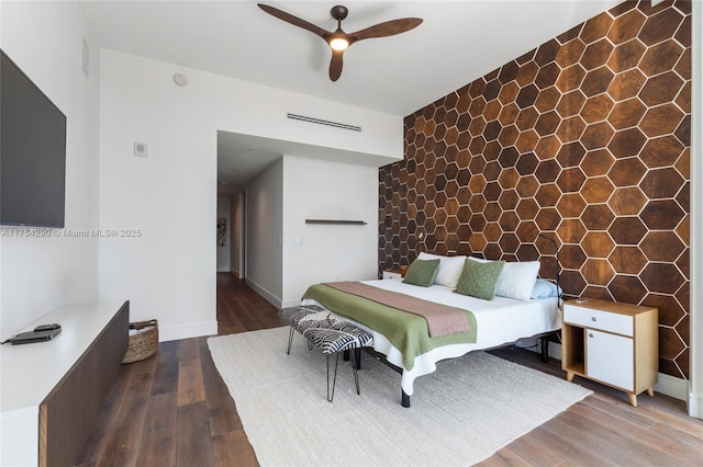 bedroom with visible vents, ceiling fan, baseboards, and wood finished floors