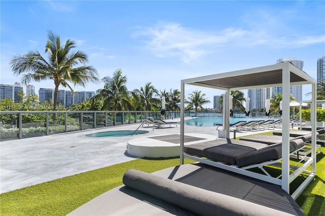 view of community with a patio area, fence, a pool, and a city view