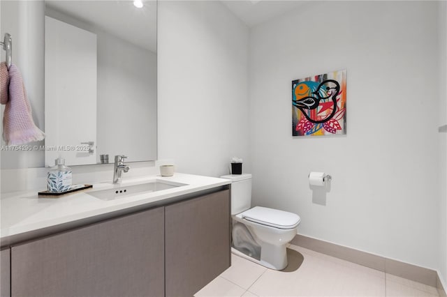 bathroom with toilet, tile patterned flooring, baseboards, and vanity