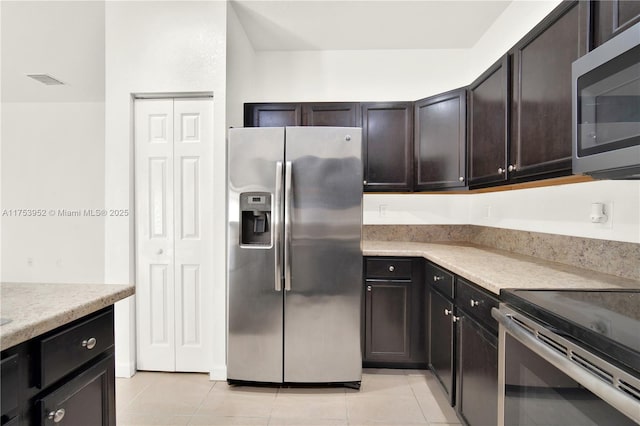 kitchen with light tile patterned floors, appliances with stainless steel finishes, light countertops, and dark brown cabinets