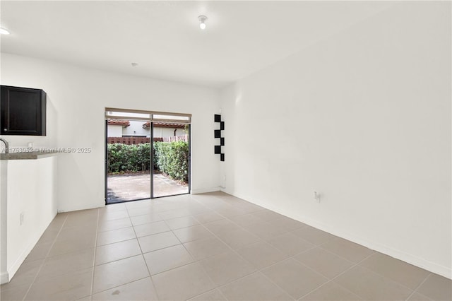 unfurnished room featuring light tile patterned floors and baseboards