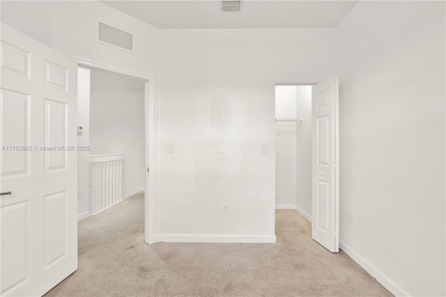 unfurnished room with light colored carpet, visible vents, and baseboards