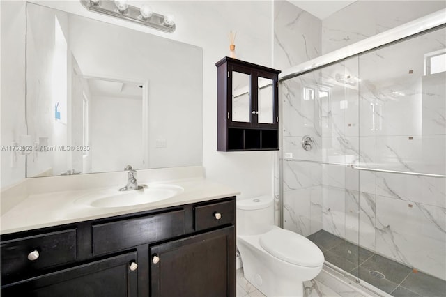 bathroom featuring toilet, a marble finish shower, and vanity