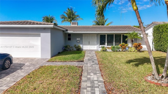 ranch-style house with a garage, stucco siding, a tile roof, decorative driveway, and a front yard