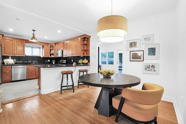 kitchen with dark countertops, tasteful backsplash, appliances with stainless steel finishes, and open shelves