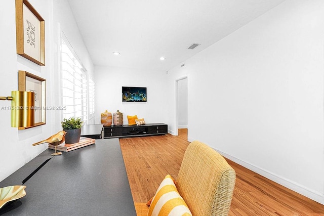 living room with baseboards, visible vents, wood finished floors, and recessed lighting