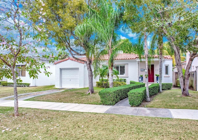 mediterranean / spanish-style home with a garage, a tile roof, concrete driveway, stucco siding, and a front lawn