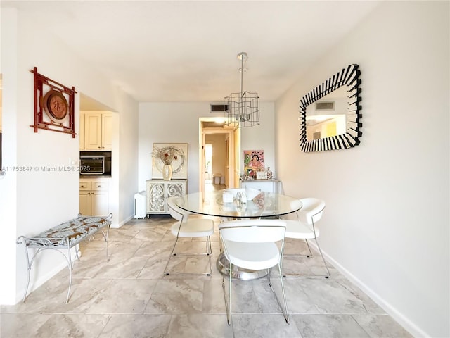 unfurnished dining area featuring baseboards, visible vents, and a notable chandelier