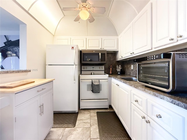 kitchen featuring lofted ceiling, white appliances, white cabinets, and backsplash