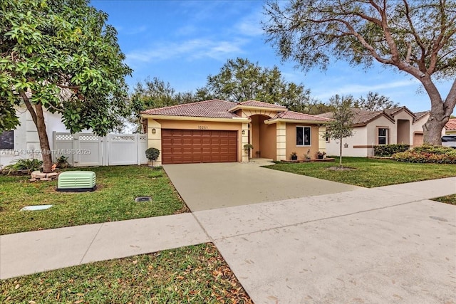 view of front of home with a garage, a tile roof, fence, driveway, and a front lawn