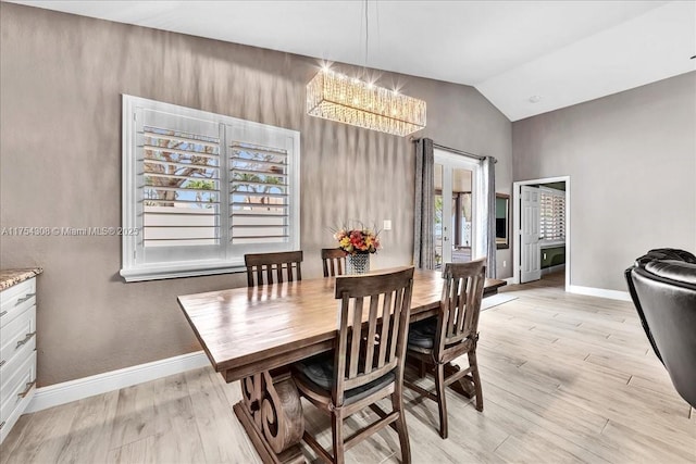 dining space featuring lofted ceiling, baseboards, light wood finished floors, and an inviting chandelier