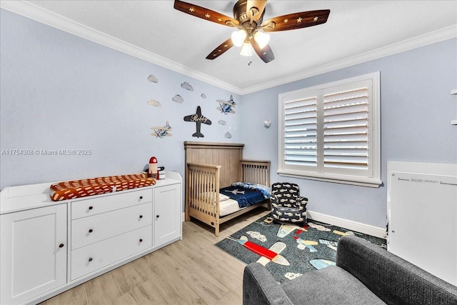 bedroom featuring baseboards, ornamental molding, a ceiling fan, and light wood-style floors