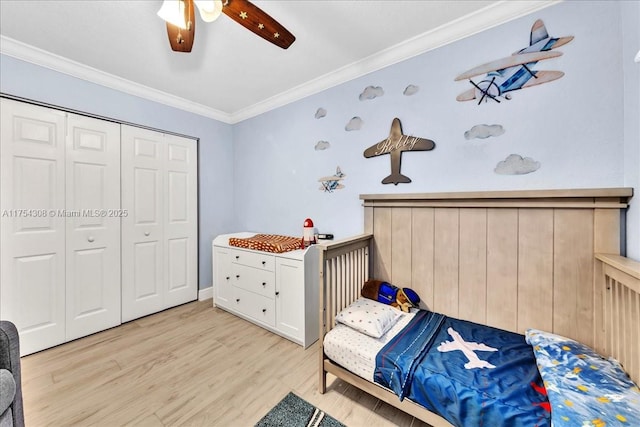 bedroom featuring ornamental molding, a closet, light wood-style floors, and a ceiling fan