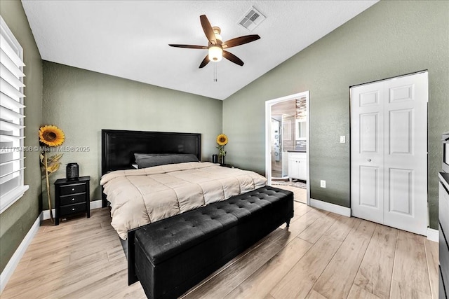 bedroom featuring baseboards, visible vents, vaulted ceiling, and light wood finished floors