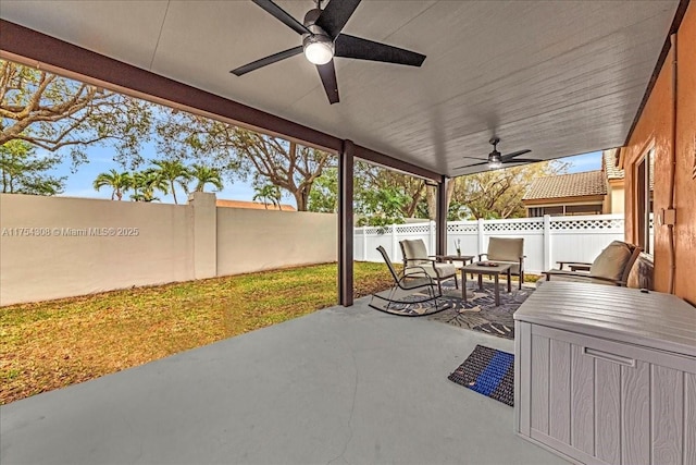 view of patio with a fenced backyard, an outdoor living space, and a ceiling fan