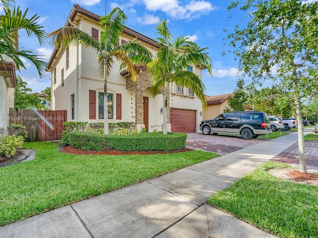 mediterranean / spanish house featuring driveway, an attached garage, fence, a front lawn, and stucco siding