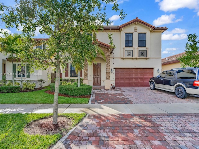 view of front of house featuring decorative driveway, a tiled roof, an attached garage, and stucco siding