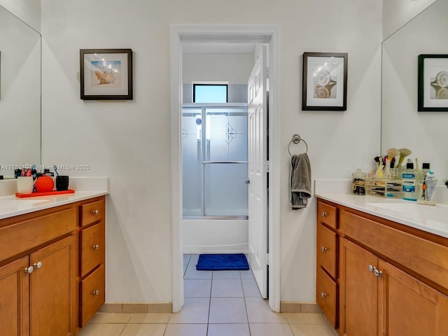 bathroom with baseboards, shower / bath combination with glass door, vanity, and tile patterned floors