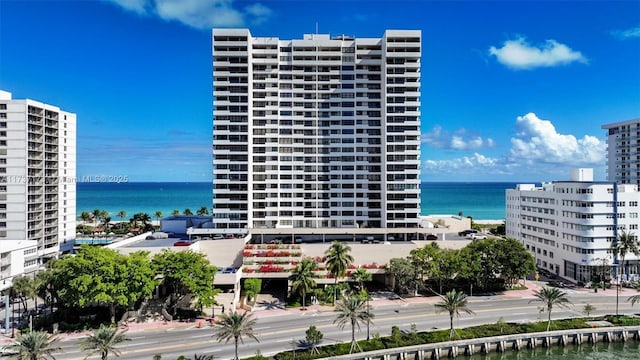 view of building exterior featuring a water view and a city view