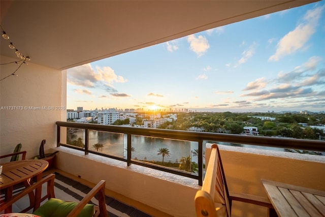 balcony at dusk featuring a city view