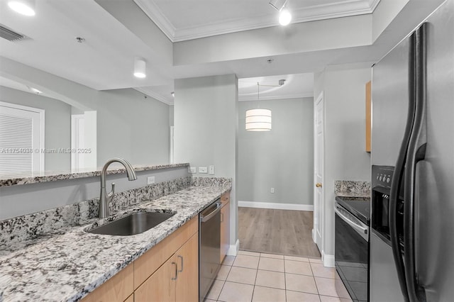 kitchen featuring light tile patterned floors, appliances with stainless steel finishes, a sink, and crown molding