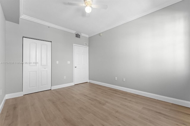 unfurnished bedroom featuring baseboards, visible vents, crown molding, and light wood finished floors