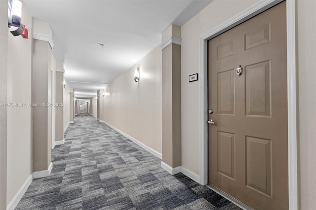 corridor featuring carpet flooring and baseboards