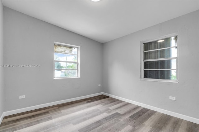 empty room featuring wood finished floors and baseboards