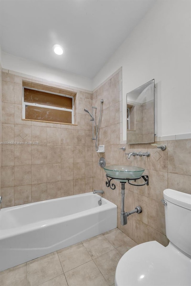 full bath featuring toilet, tile patterned flooring, bathtub / shower combination, and tile walls