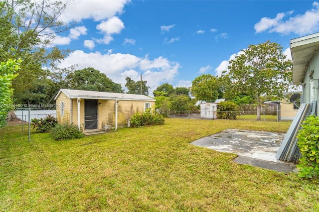 view of yard featuring a fenced backyard, an outdoor structure, and a patio