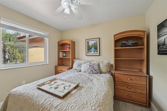 bedroom with a textured ceiling, a ceiling fan, and baseboards