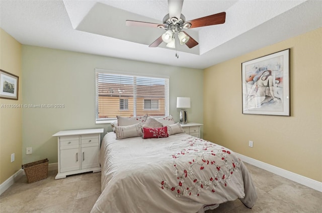 bedroom featuring light tile patterned floors, a textured ceiling, baseboards, and a ceiling fan