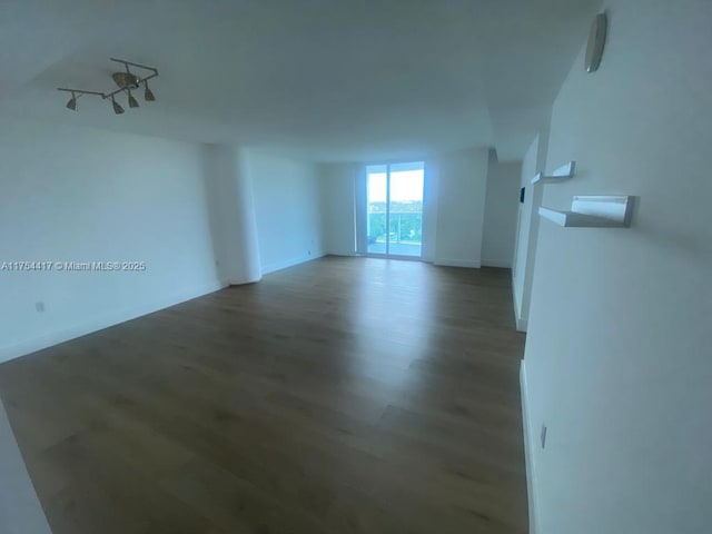 unfurnished room with baseboards and wood finished floors