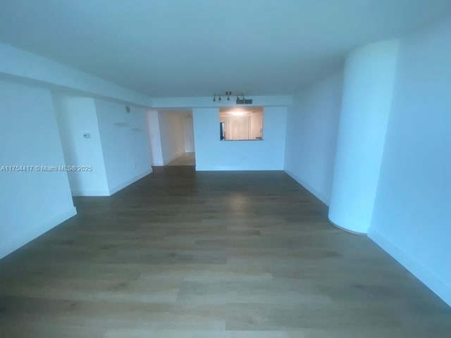 unfurnished room featuring baseboards and wood finished floors